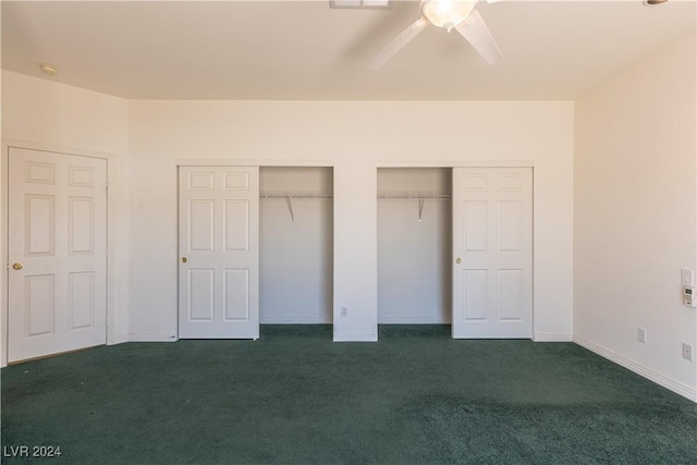 unfurnished bedroom featuring baseboards, two closets, a ceiling fan, and dark colored carpet