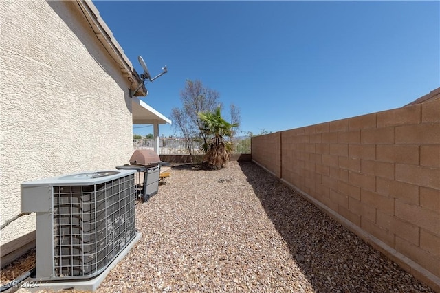 view of yard with central AC unit and a fenced backyard
