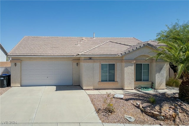 ranch-style house with a tiled roof, an attached garage, and stucco siding