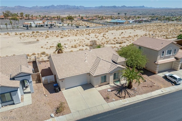 drone / aerial view featuring a mountain view and a desert view
