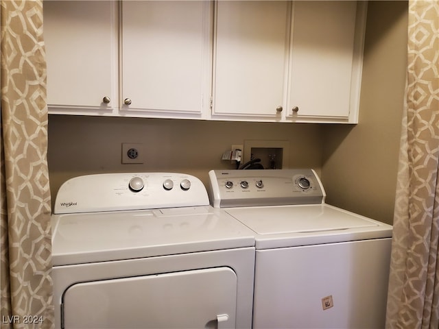 clothes washing area featuring cabinets and washing machine and clothes dryer