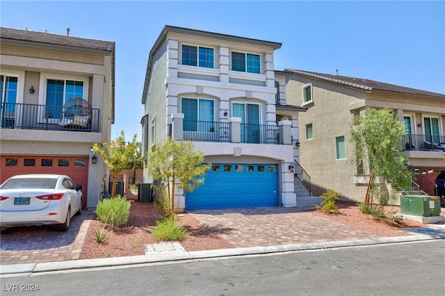 view of property featuring a balcony, a garage, and central AC