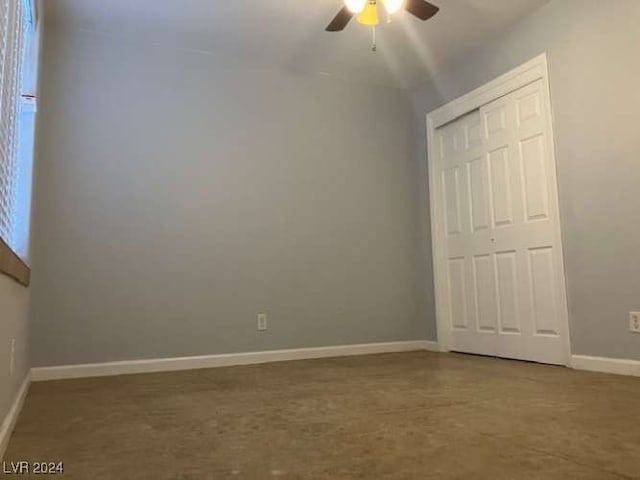 unfurnished bedroom with lofted ceiling, ceiling fan, concrete flooring, and a closet