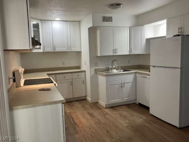 kitchen with dark hardwood / wood-style floors, white appliances, sink, and white cabinets