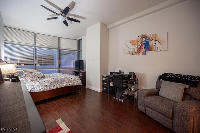 bedroom with wood finished floors, baseboards, a ceiling fan, and an office area