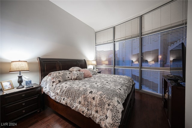 bedroom with vaulted ceiling and dark hardwood / wood-style floors