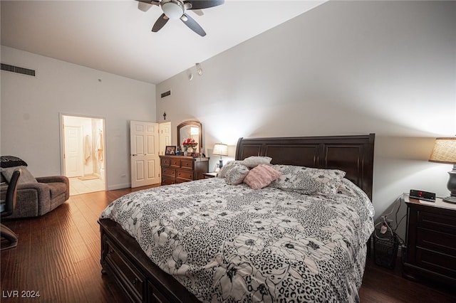 bedroom with ceiling fan, vaulted ceiling, connected bathroom, and dark hardwood / wood-style flooring