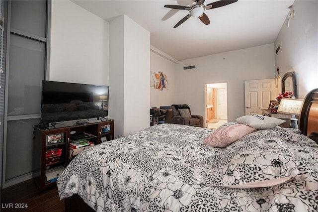 bedroom with dark wood-type flooring, a ceiling fan, baseboards, and connected bathroom