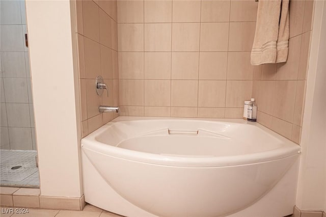 bathroom featuring a bath, tile walls, tile patterned floors, and a shower