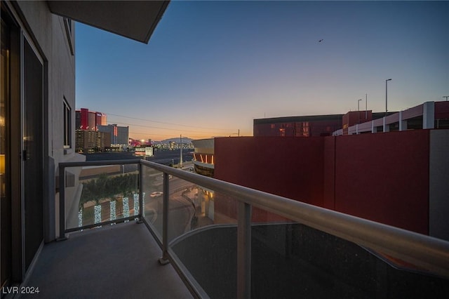 balcony at dusk featuring a view of city