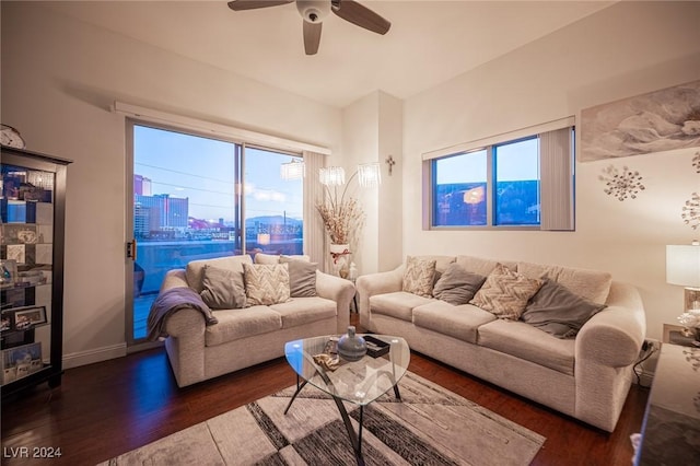 living area with wood finished floors, ceiling fan, baseboards, and a view of city