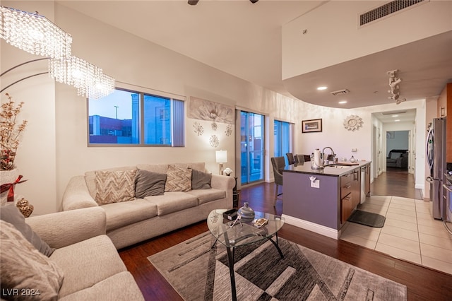 living room featuring a chandelier, dark wood-type flooring, and sink