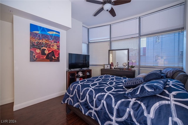 bedroom featuring ceiling fan, dark hardwood / wood-style floors, and multiple windows