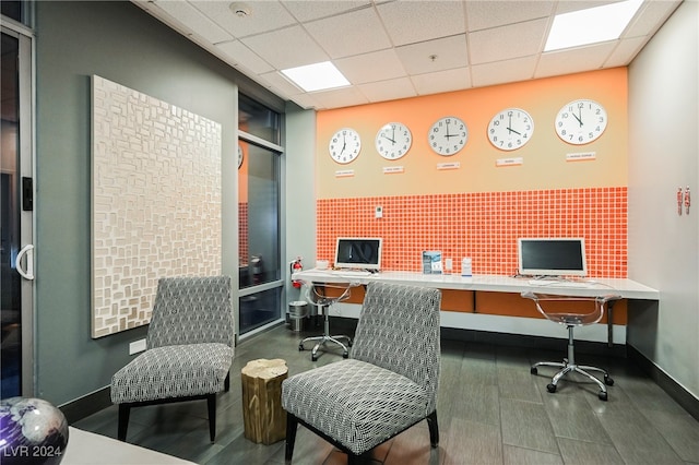 office with dark hardwood / wood-style flooring, built in desk, and a paneled ceiling