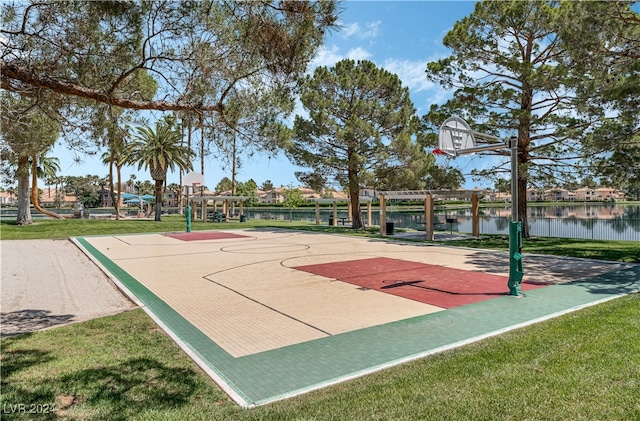 view of sport court featuring a yard, a pergola, and a water view