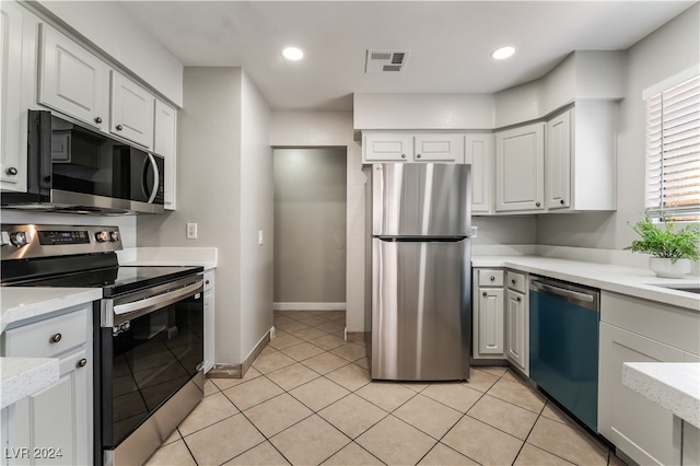 kitchen with light tile patterned flooring, white cabinetry, and stainless steel appliances