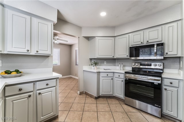 kitchen featuring light tile patterned floors, stainless steel appliances, gray cabinets, and ceiling fan