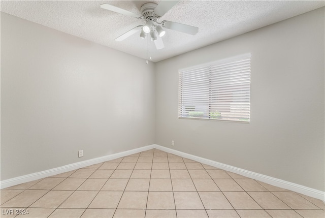 spare room featuring light tile patterned floors, a textured ceiling, and ceiling fan