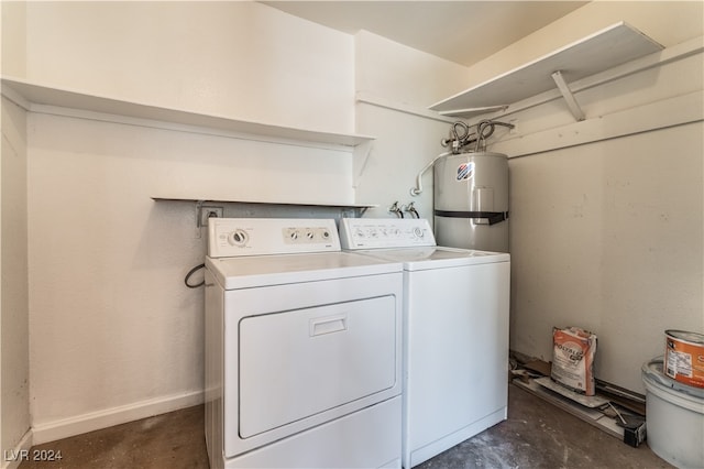 clothes washing area with washer and clothes dryer and water heater