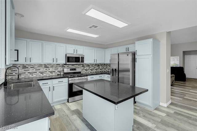 kitchen featuring light hardwood / wood-style floors, a center island, sink, white cabinetry, and appliances with stainless steel finishes