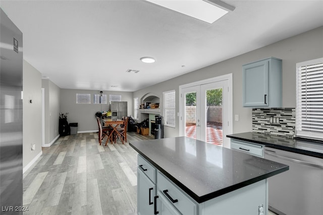 kitchen with a center island, light hardwood / wood-style flooring, backsplash, french doors, and stainless steel dishwasher