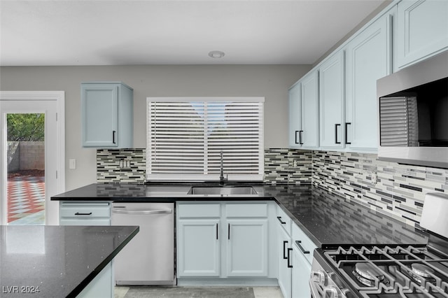 kitchen featuring dark stone countertops, appliances with stainless steel finishes, sink, and tasteful backsplash