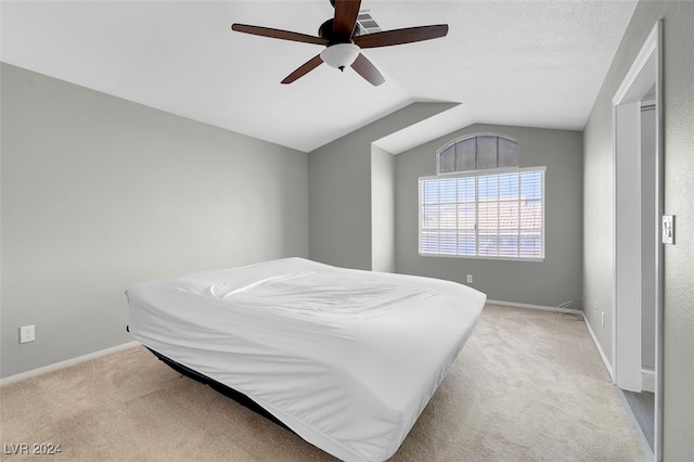 bedroom featuring ceiling fan, light colored carpet, and lofted ceiling