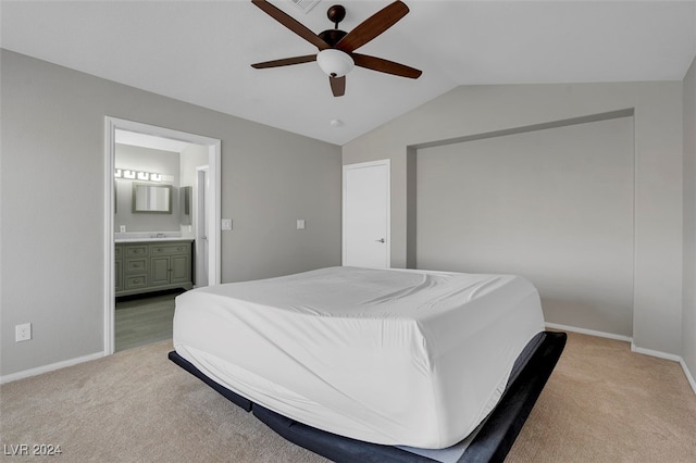 bedroom with vaulted ceiling, light carpet, ceiling fan, and ensuite bath