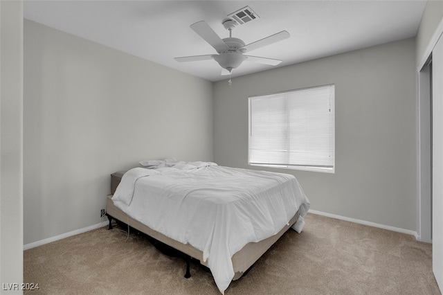 carpeted bedroom with ceiling fan and a closet