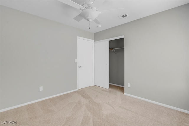 unfurnished bedroom with light carpet, ceiling fan, and a closet