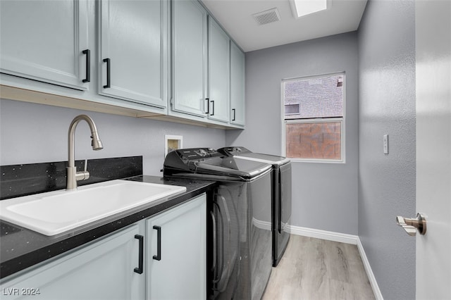 washroom with cabinets, light hardwood / wood-style floors, sink, and independent washer and dryer