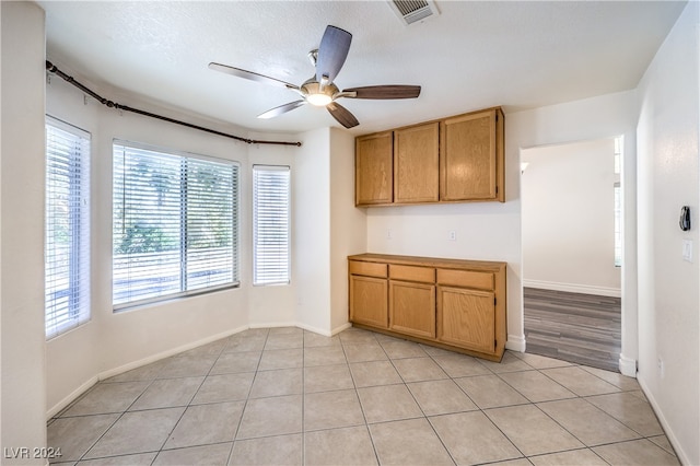 kitchen with ceiling fan, light tile patterned floors, and a textured ceiling