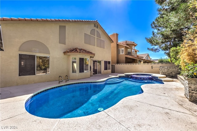 view of swimming pool featuring a patio and an in ground hot tub