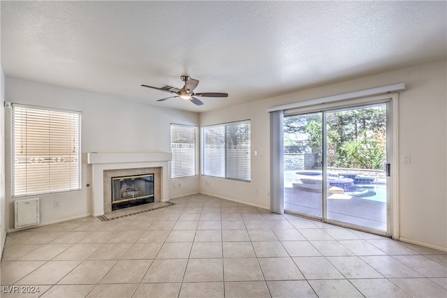 unfurnished living room featuring ceiling fan, a textured ceiling, and light tile patterned floors