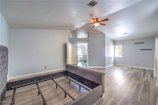 interior space with a textured ceiling, lofted ceiling, ceiling fan, and hardwood / wood-style flooring