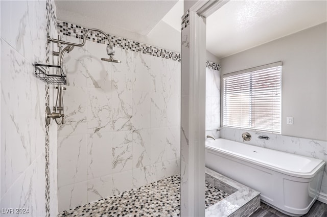 bathroom featuring plus walk in shower, a textured ceiling, and hardwood / wood-style floors