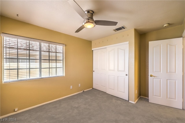 unfurnished bedroom featuring carpet, ceiling fan, and a closet