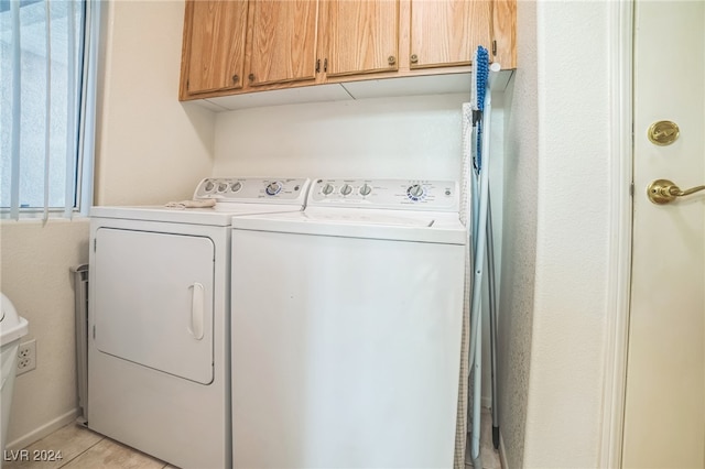 washroom with washer and clothes dryer, light tile patterned floors, and cabinets