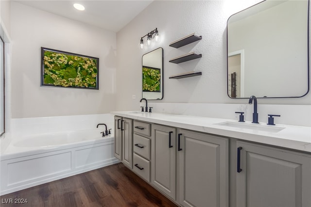 bathroom featuring wood-type flooring, a tub to relax in, and vanity