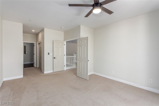 unfurnished bedroom with ceiling fan, light colored carpet, and a closet