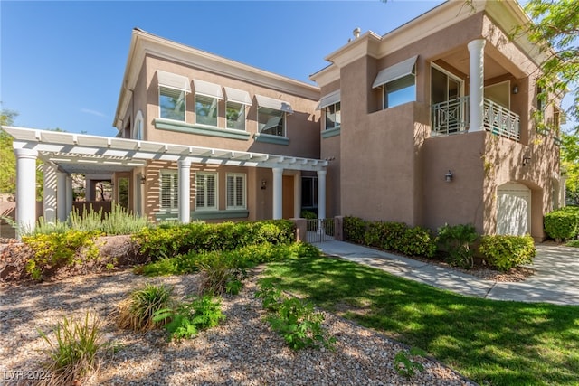 view of front of property featuring a pergola and a balcony