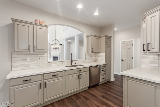 kitchen with ornate columns, dishwasher, dark wood-type flooring, and sink