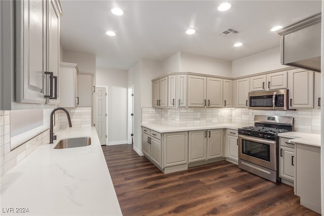 kitchen featuring sink, stainless steel appliances, backsplash, and dark hardwood / wood-style flooring