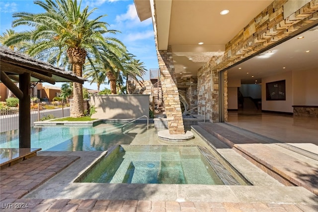 view of pool featuring a patio and an in ground hot tub