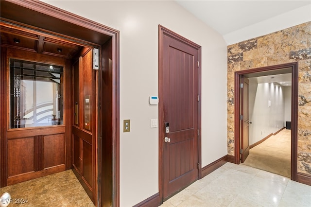 hall with elevator and light tile patterned flooring