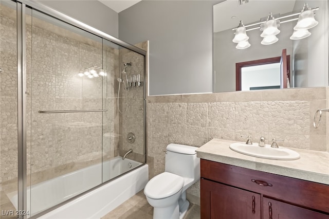 full bathroom with vanity, combined bath / shower with glass door, tile walls, toilet, and decorative backsplash