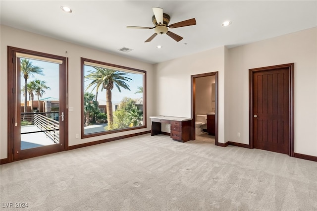 unfurnished bedroom featuring ceiling fan, ensuite bath, access to exterior, and light carpet