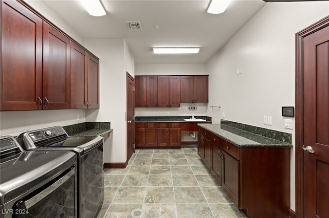 laundry room featuring sink, washing machine and clothes dryer, and cabinets