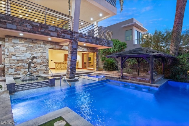 pool at dusk featuring a patio and a gazebo