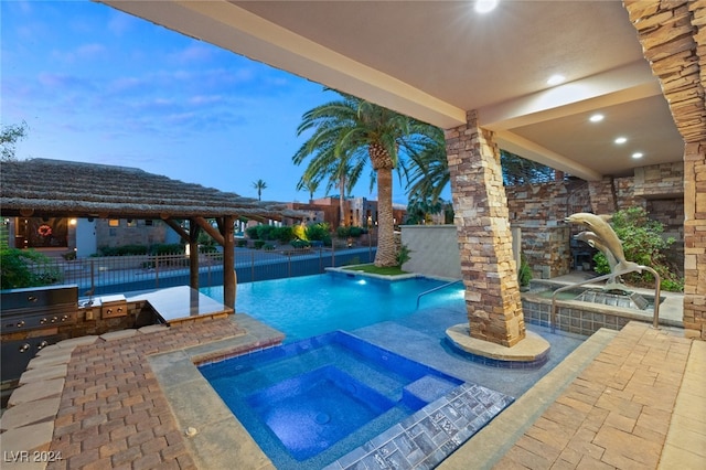 pool at dusk featuring an in ground hot tub, area for grilling, and a patio area